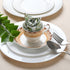 Rolled floral napkin placed upright on a white plate with silverware.