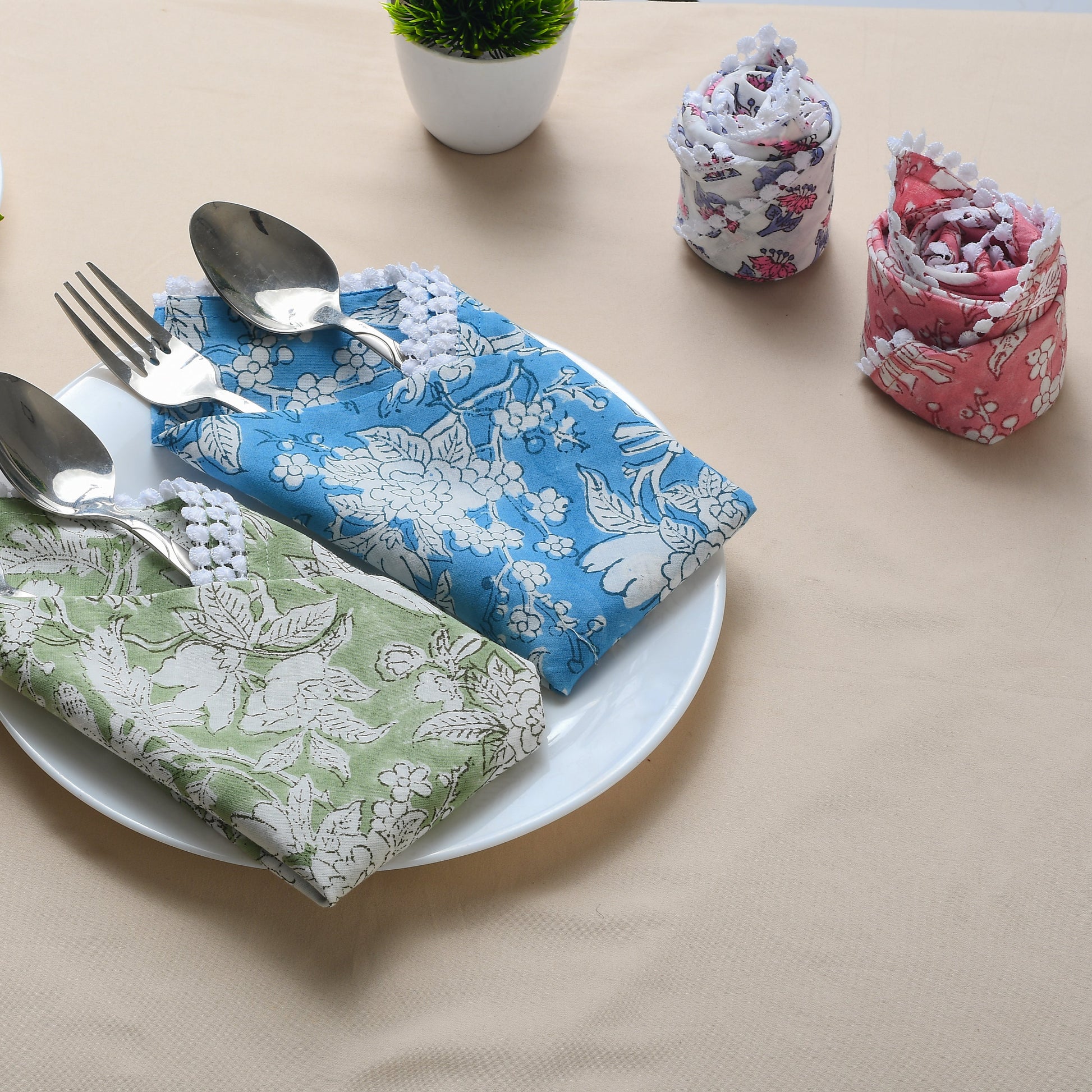 Blue block print napkin folded on tray with silverware and rolled matching napkin.