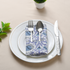 Blue floral napkin with plate and cup in flat lay setting.