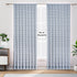 A pair of semi-sheer blue cotton block print curtains hanging in a room with a light coming through, showcasing a boho-chic design.