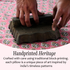Hand pressing down on a handcrafted cotton pillow cover, highlighting artisanal craftsmanship and texture