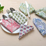 Assorted napkins laid out with floral prints and silverware for variety styling.

