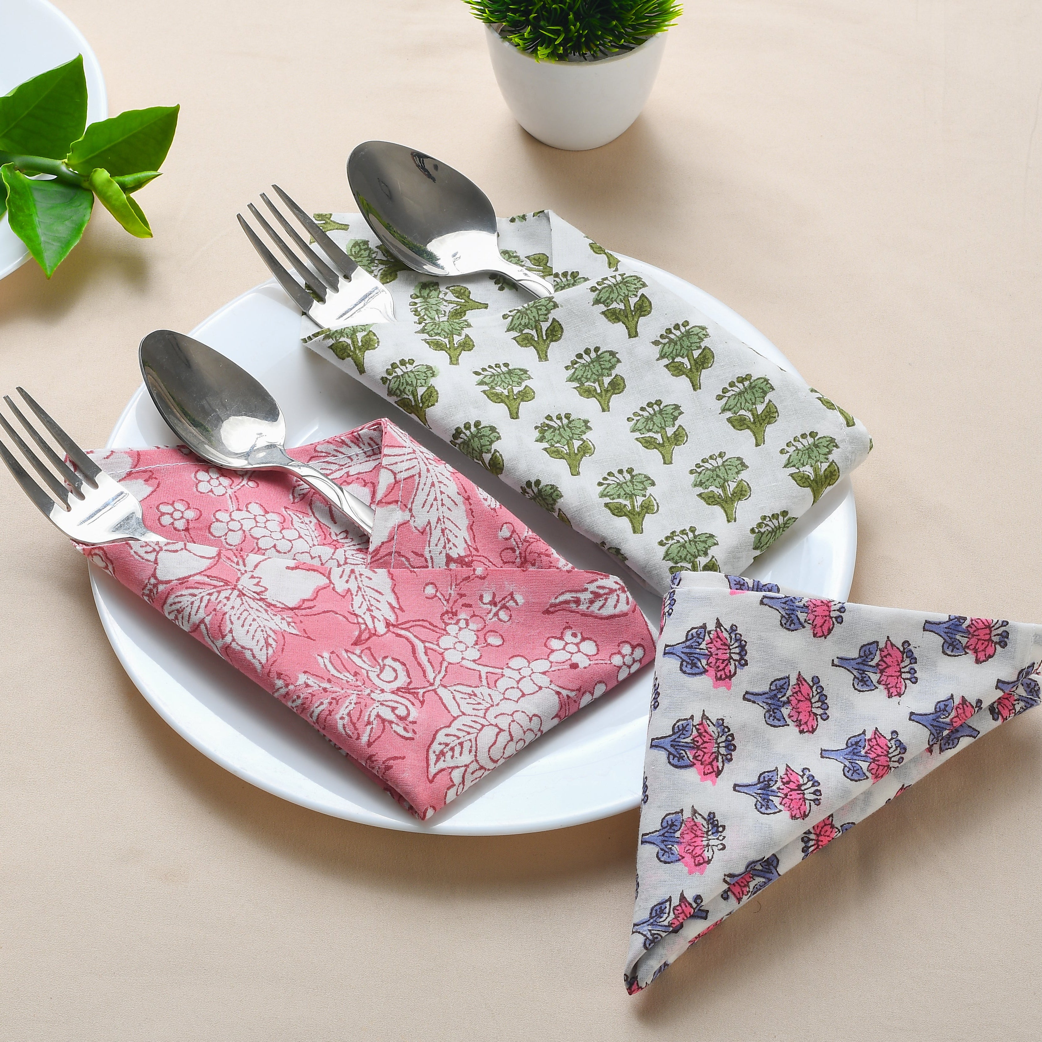 Red floral block-printed napkin laid flat on white background.

