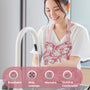 lady washing dishes and wearing a pink and white floral block print apron thats breathable, has wide coverage, washable, and stylish and comfortable