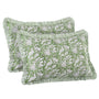 Two green patterned pillows with white fringes on a white background