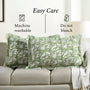 Green floral patterned pillows on a beige sofa with washing and care instructions.