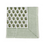 Green botanical block-printed cotton napkin in close-up.

