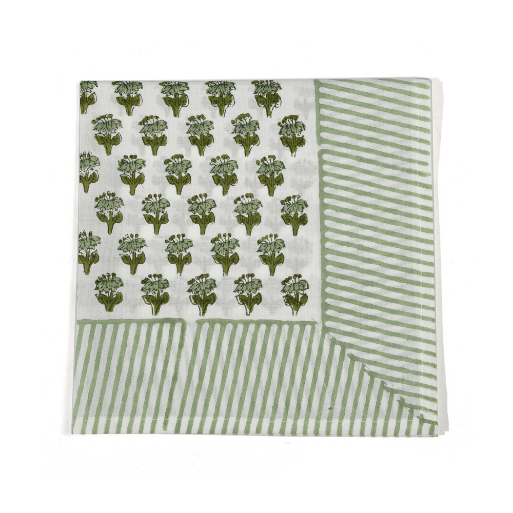 Green botanical block-printed cotton napkin in close-up.

