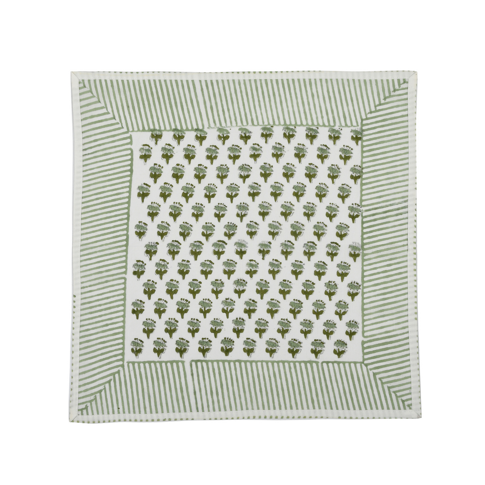 Green botanical block-printed cotton napkin in close-up.

