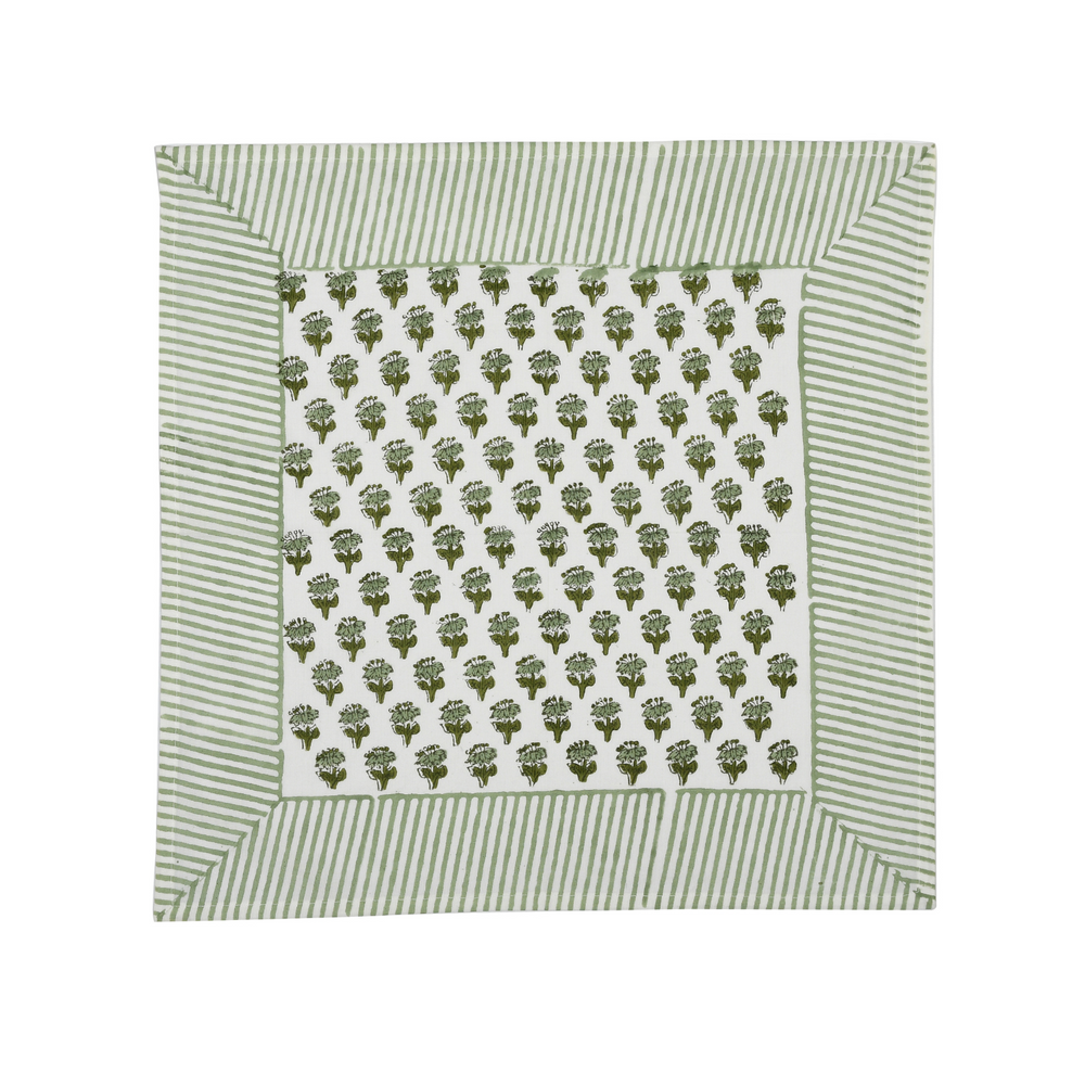 Green botanical block-printed cotton napkin in close-up.

