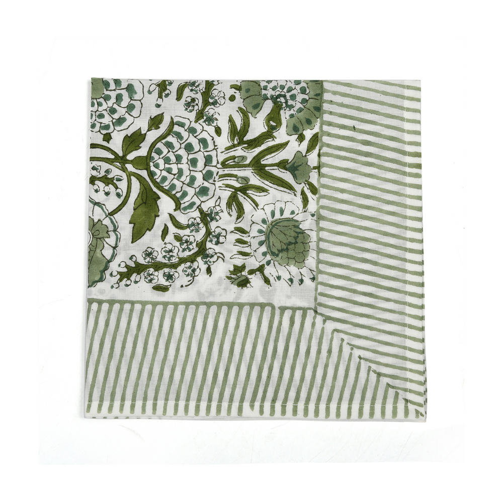 Green botanical block-printed cotton napkin in close-up.

