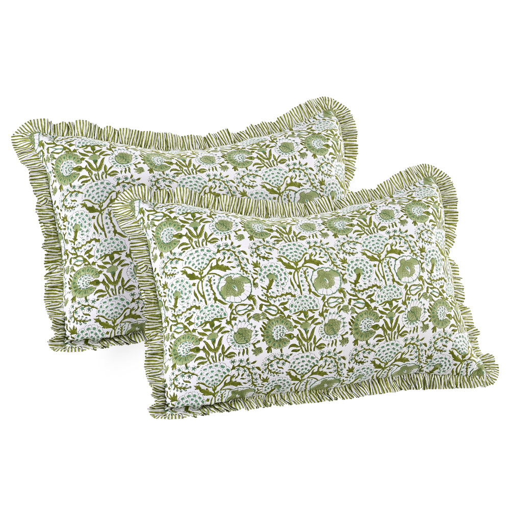 Two green floral patterned pillows with ruffled edges on a white background