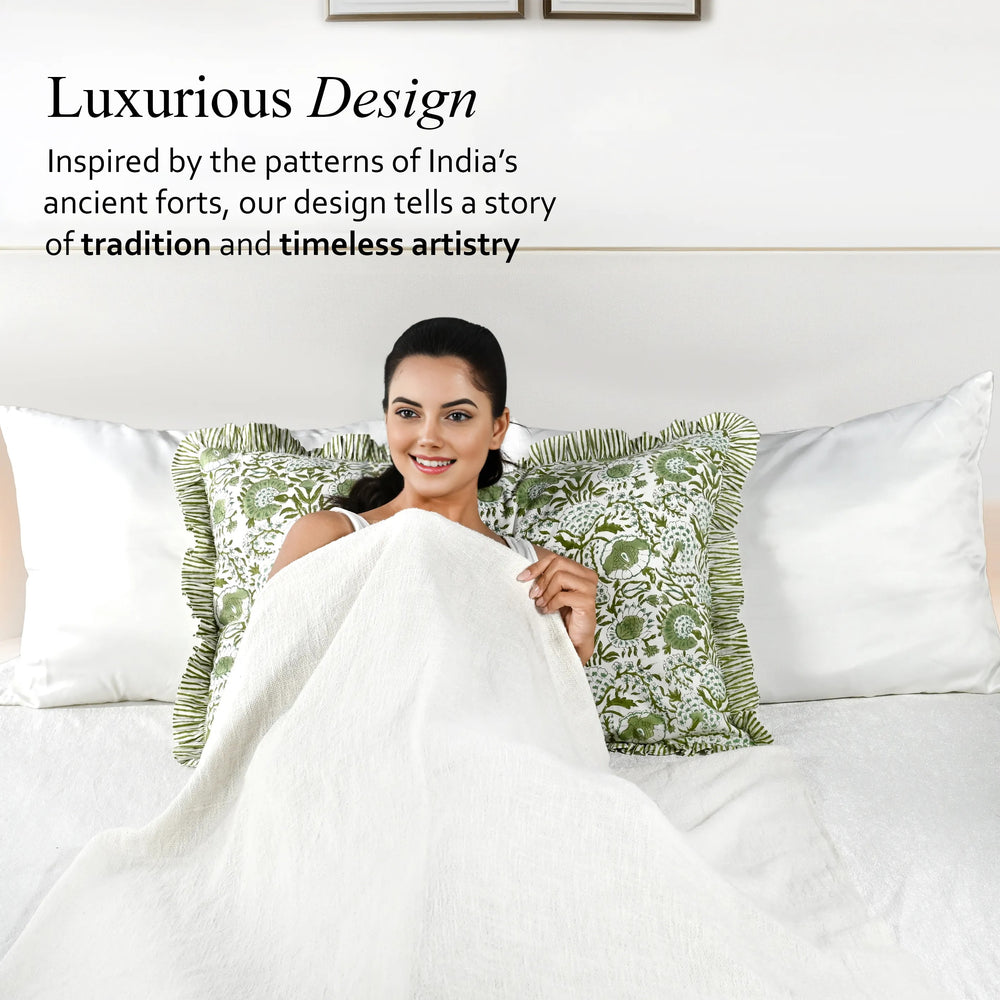 Woman on a bed with decorative pillows and bedding, text about luxurious design inspired by India's ancient forts.