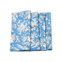 A set of folded blue cotton cloth napkins with white floral and geometric patterns.