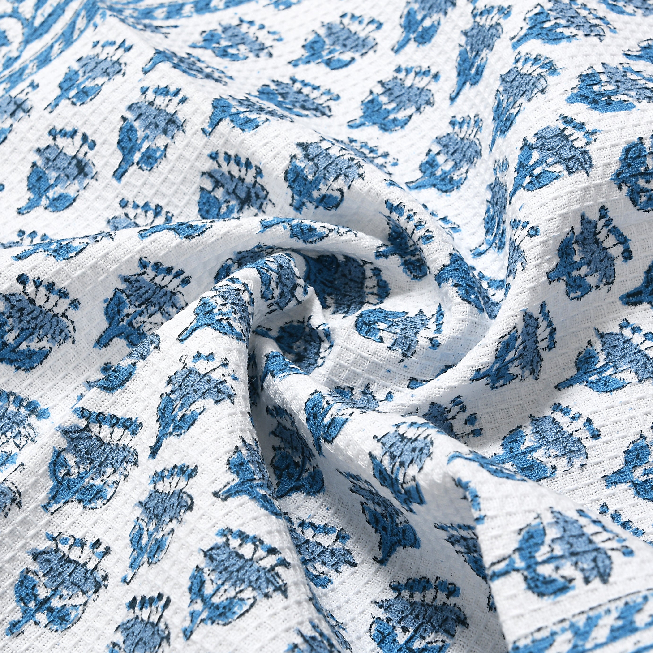 Corner fold view of towel showing floral design and waffle texture
