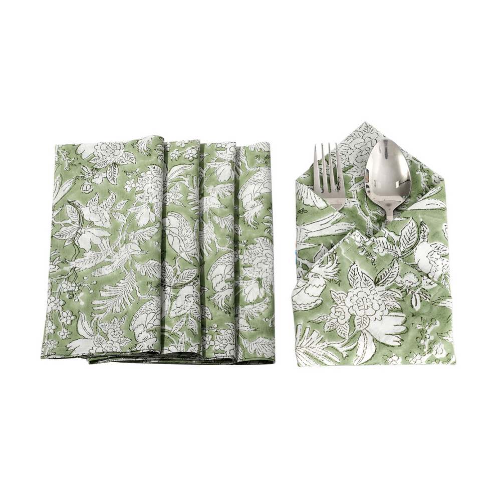 Six green floral napkins displayed in a fan arrangement with a single folded one in the center holding silverware.