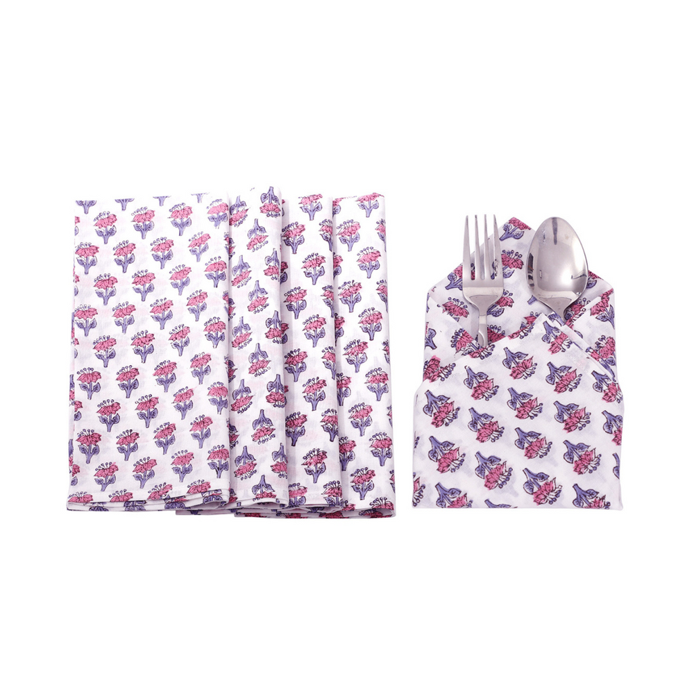 Six pink and white floral napkins displayed in a fan arrangement with a single folded one in the center holding silverware.