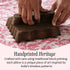Traditional block-printing process on a pillow with text about handprinted heritage.
