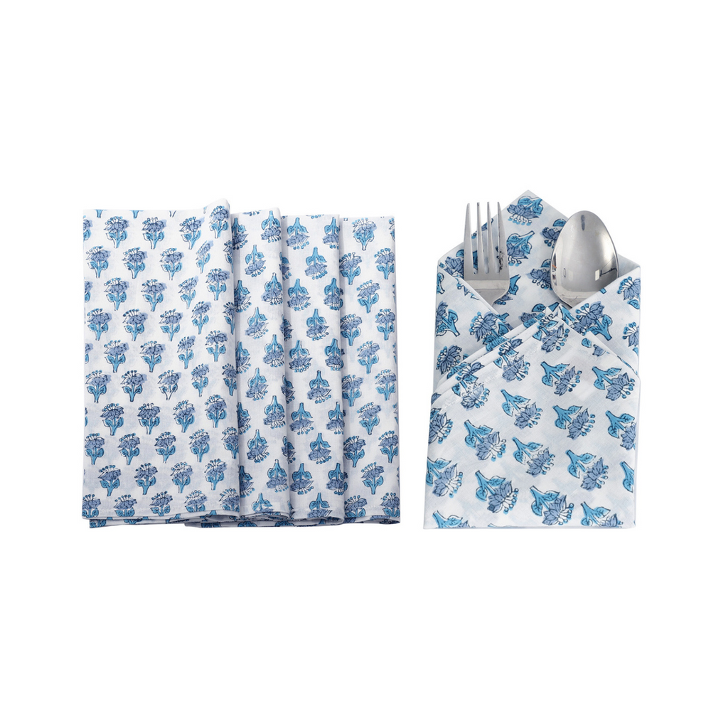 Six blue floral napkins displayed in a fan arrangement with a single folded one in the center holding silverware.

