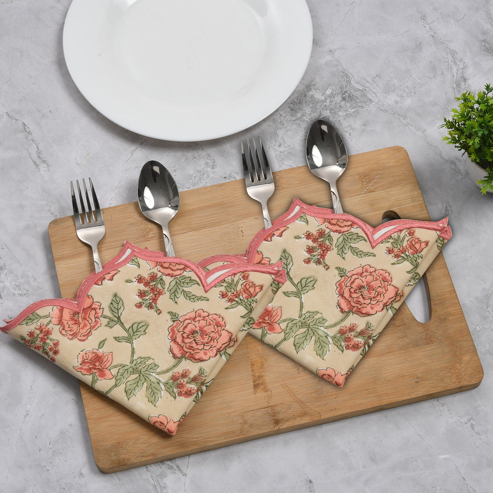 Fire opal rose handprinted embroidery detail on cotton placemat sitting on top of wooden cutting board
