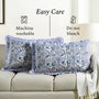 Decorative pillows with blue floral patterns on a beige couch, featuring text about care instructions.