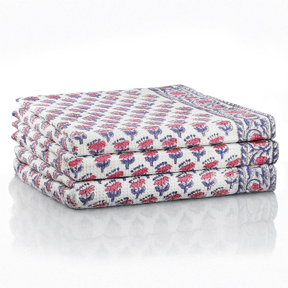 Set of three folded pink waffle cotton towels with floral hand block print

