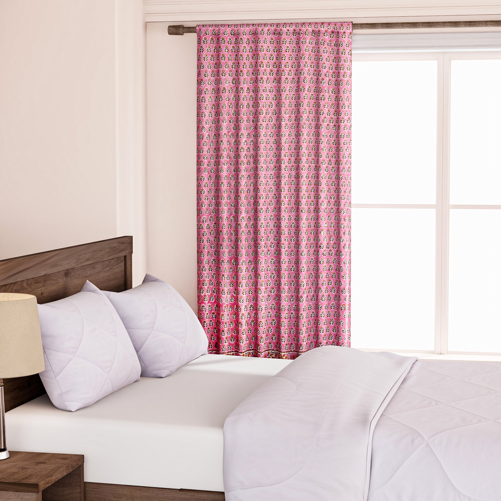 Semi-sheer cotton block print curtains in poppy pink with intricate patterns, hanging in a room with a light filtering through.