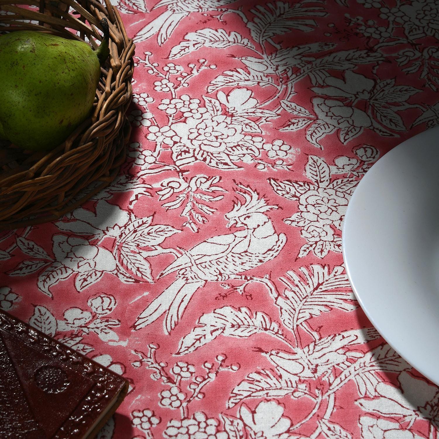 a plate of food and a basket of fruit on a table