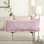 Pink block print bolster pillow on beige sofa with ruffle trim